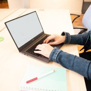 Hands typing on a laptop