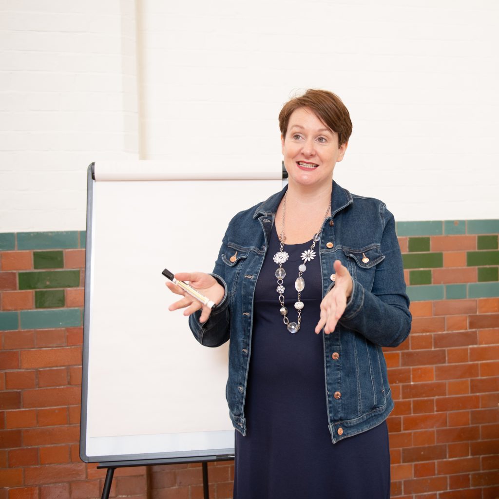 Catherine Jones of Clean Slate Copy School delivers a training session in front of a flip chart,